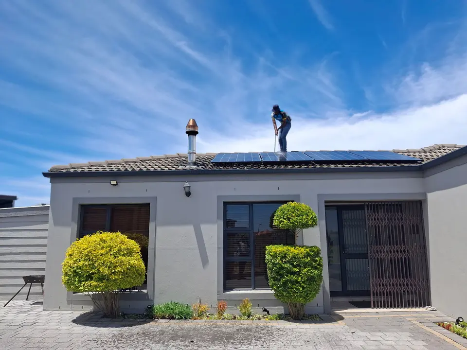 Technician installing solar panels on a rooftop